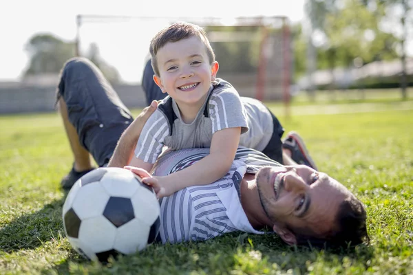 Man med barn som spelar fotboll på fältet — Stockfoto