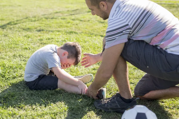 Hombre con niño jugando al fútbol en el campo — Foto de Stock