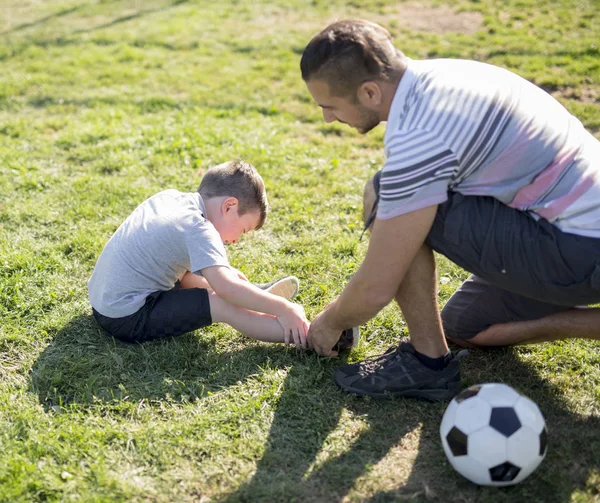 Hombre con niño jugando al fútbol en el campo — Foto de Stock