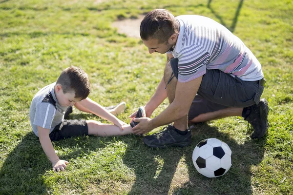 Homme avec enfant jouant au football sur le terrain — Photo