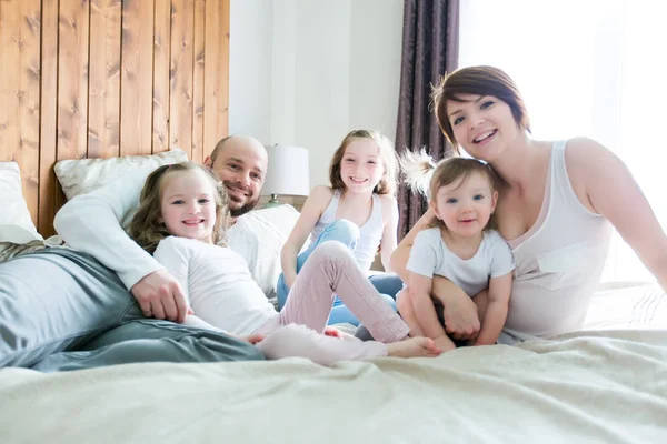 Jonge gelukkige familie van vijf op slaapkamer — Stockfoto