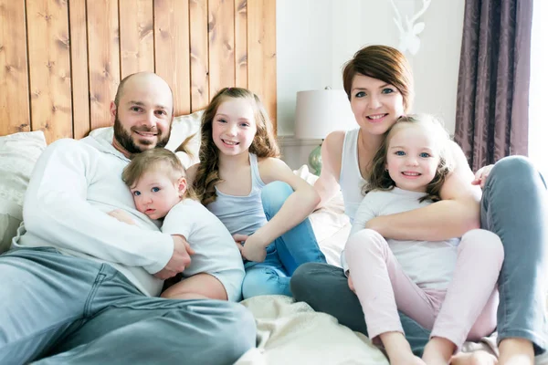 Joven familia feliz de cinco en el dormitorio —  Fotos de Stock