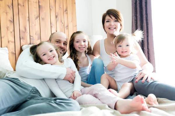 Jonge gelukkige familie van vijf op slaapkamer — Stockfoto