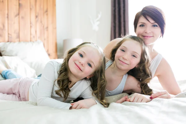 Mère et deux enfants dans la chambre sur le lit — Photo