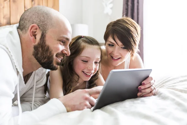 Mãe pai e seu filho com tablet digital relaxante em casa — Fotografia de Stock