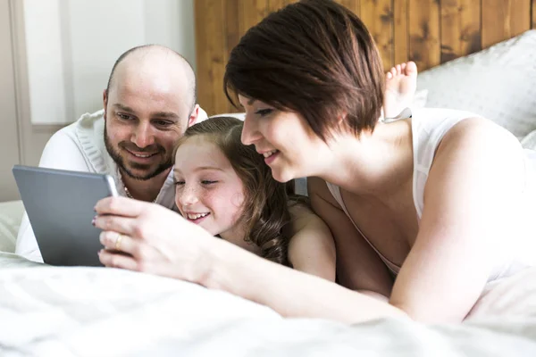 Moeder vader en haar kind met digitale tablet ontspannen thuis — Stockfoto