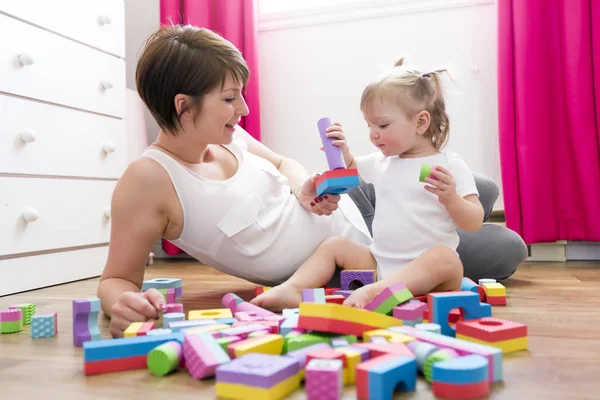 Mãe e criança brincando de brinquedos de bloco em casa — Fotografia de Stock