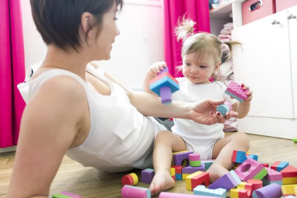 Mãe e criança brincando de brinquedos de bloco em casa — Fotografia de Stock