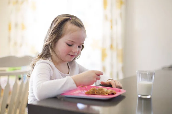 Mooi meisje consumptiemelk en dessert eten — Stockfoto