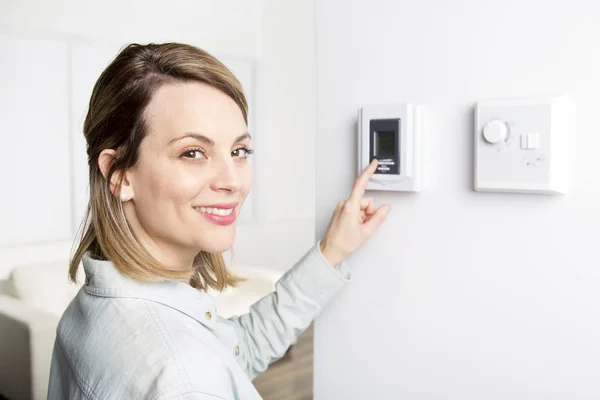 Mulher definir o termostato em casa . — Fotografia de Stock