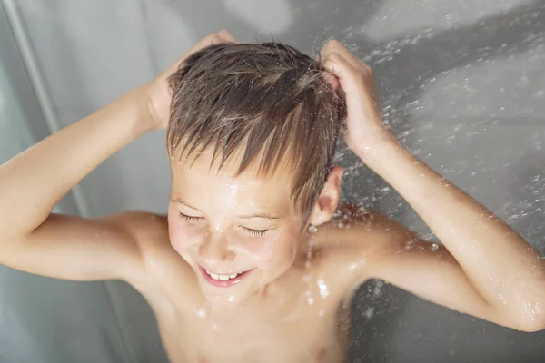 Gelukkig tiener jongen wassen hoofd in de douche in de badkamer — Stockfoto