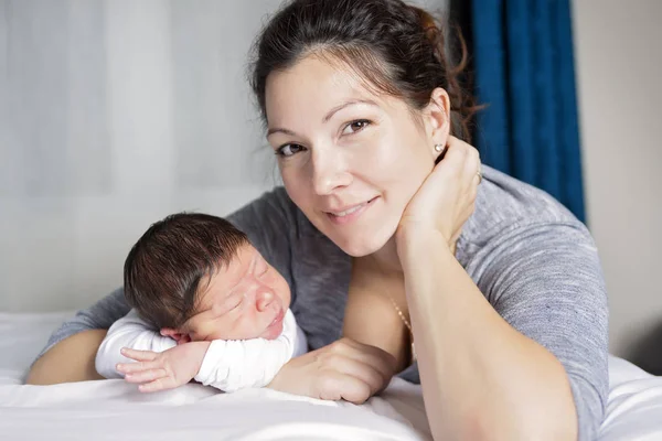 Felice madre e bambino sdraiato sul letto a casa — Foto Stock