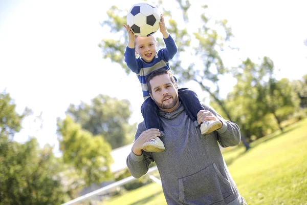 Far och son spelar boll i parken — Stockfoto