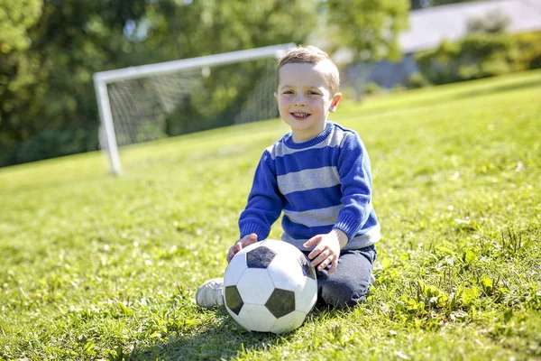 Niño con pelota de fútbol en el parque — Foto de Stock