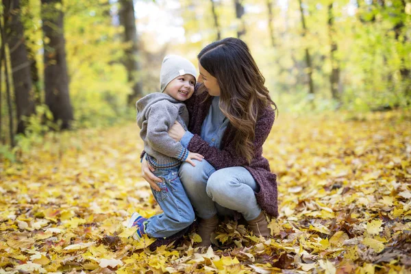 Moeder met zoon in bos in de herfst — Stockfoto