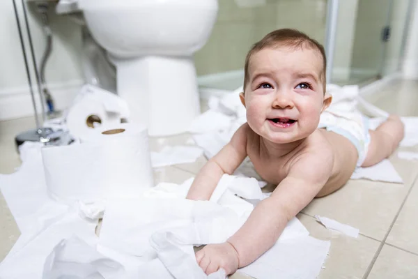 Criança rasgando papel higiênico no banheiro — Fotografia de Stock