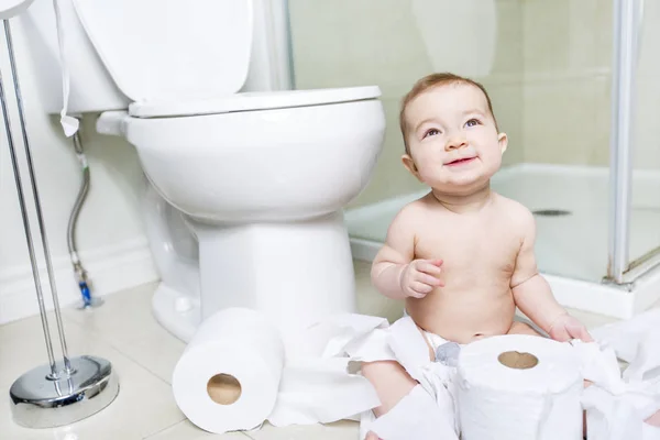 Tout-petit déchirant du papier toilette dans la salle de bain — Photo