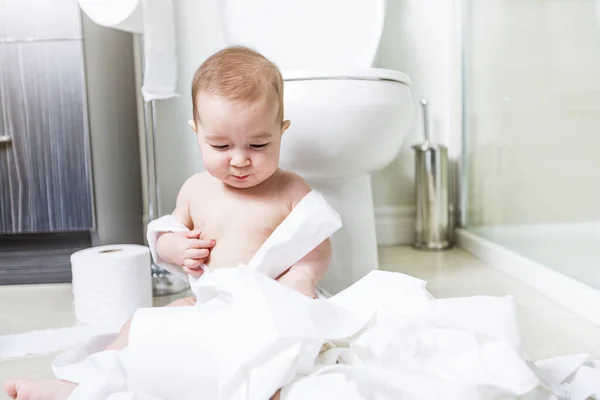 Tout-petit déchirant du papier toilette dans la salle de bain — Photo
