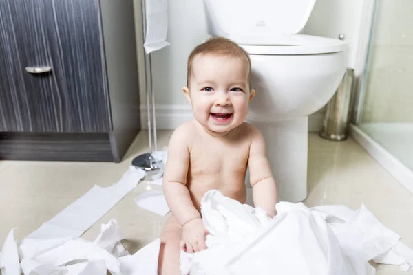 Tout-petit déchirant du papier toilette dans la salle de bain — Photo