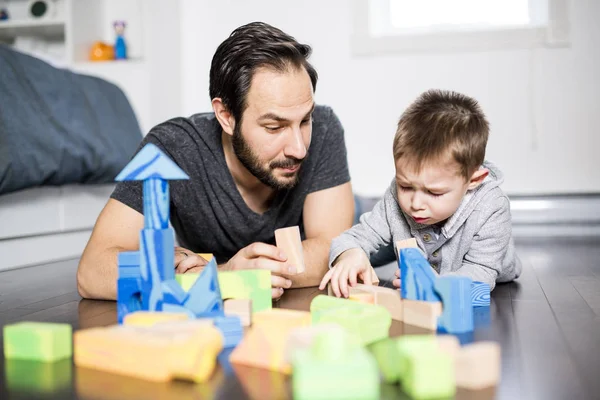 Bonito criança brincando com cor brinquedo interior com é pai — Fotografia de Stock