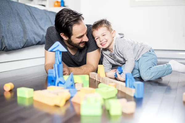 Bonito criança brincando com cor brinquedo interior com é pai — Fotografia de Stock