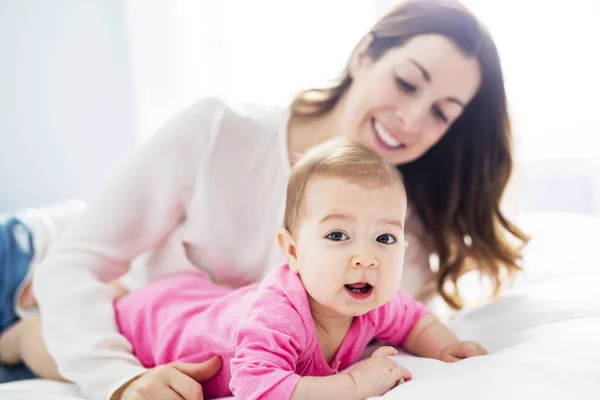 Mère et bébé enfant sur un lit blanc . — Photo