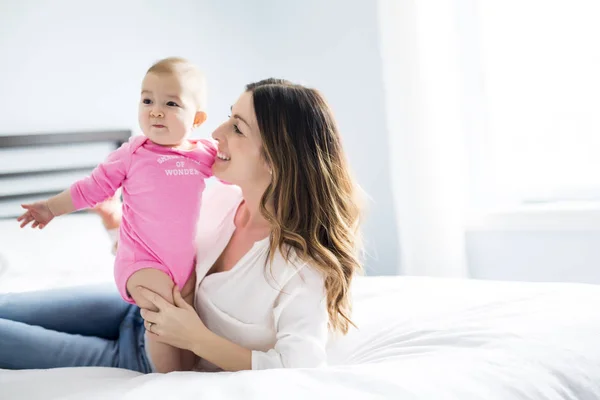 Mère et bébé enfant sur un lit blanc . — Photo