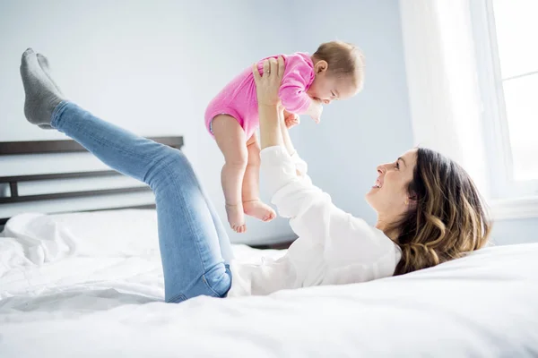 Mère et bébé enfant sur un lit blanc . — Photo