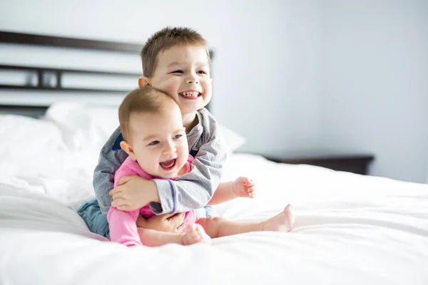 Bebê e seu irmão na cama — Fotografia de Stock