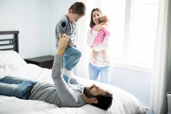 Quatro povos família em uma cama branca . — Fotografia de Stock