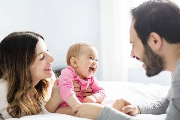 Madre padre e hijo bebé en una cama blanca. — Foto de Stock