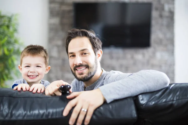 Pai e filhos no sofá em casa assistindo TV juntos — Fotografia de Stock