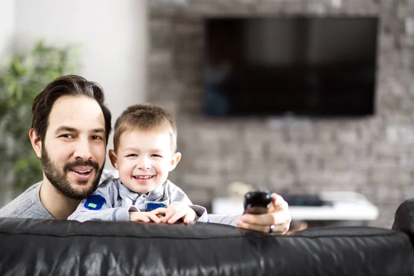Padre e bambini sul divano a casa a guardare la TV insieme — Foto Stock