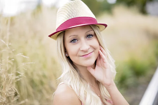 Belle et jeune fille dans un chapeau marchant dans la ville du soir — Photo