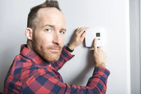 Männer stellen das Thermostat zu Hause ein — Stockfoto