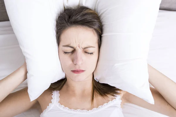 Giovane donna addormentata in camera da letto a casa indossando in bianco — Foto Stock