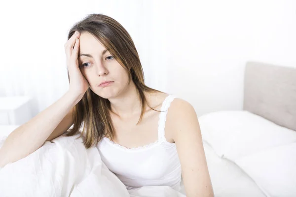 Jeune femme endormie dans la chambre à coucher à la maison portant en blanc — Photo