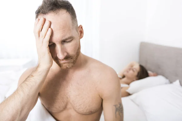 Deprimido homem sentado na borda da cama no quarto — Fotografia de Stock