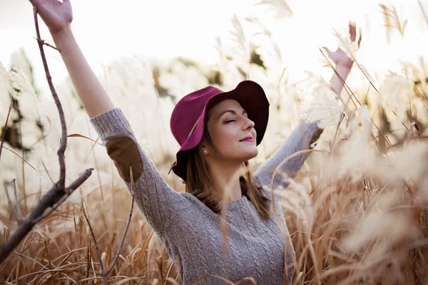 Mujer en un campo de trigo al atardecer — Foto de Stock