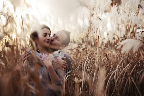 Joven moda hermosa pareja de estilo casual amoroso en el campo floral en el parque otoñal —  Fotos de Stock