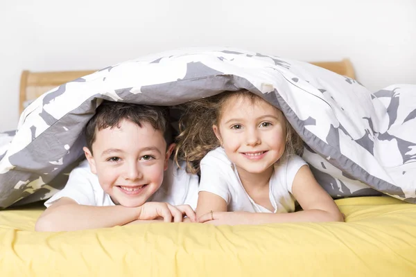 Irmão e irmã relaxando juntos na cama — Fotografia de Stock