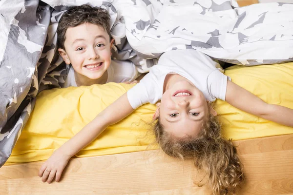 Broer en zus ontspannen samen in bed — Stockfoto