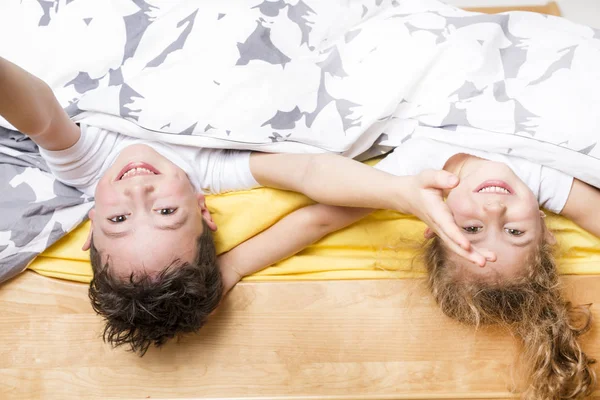 Irmão e irmã relaxando juntos na cama — Fotografia de Stock