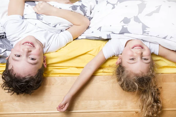 Broer en zus ontspannen samen in bed — Stockfoto
