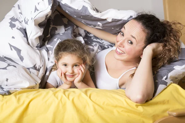 Μητέρα και κόρη στο σπίτι στο κρεβάτι. — Φωτογραφία Αρχείου