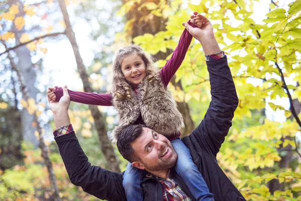 Petite fille adorable avec père heureux dans le parc d'automne en plein air — Photo