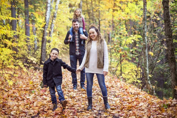 Vierköpfige Familie genießt goldenes Laub im Herbstpark — Stockfoto