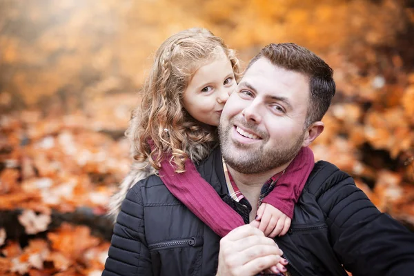 Petite fille adorable avec père heureux dans le parc d'automne en plein air — Photo
