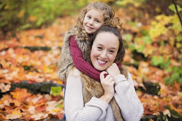 Young mother playing with her daughter in autumn park — Stock Photo, Image