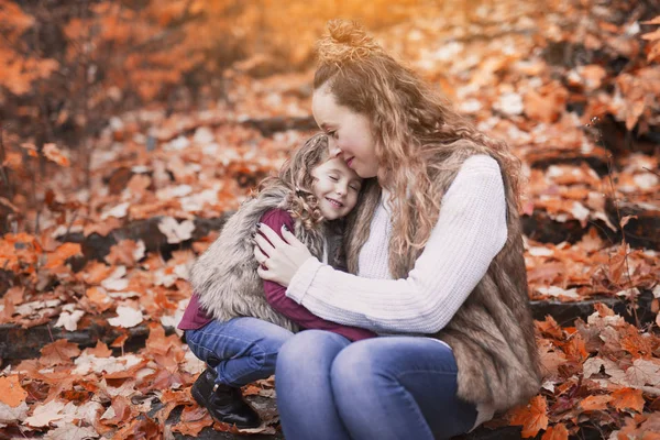 Junge Mutter spielt mit ihrer Tochter im Herbstpark — Stockfoto